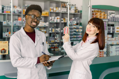 specialist of pharmacy making notes on clipboard during inventory in drugstore